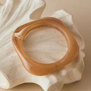 Close-up of translucent amber resin bracelet with irregular organic square design