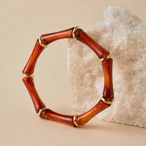 Detalle de una pulsera vintage de acrílico con diseño de bambú y textura de ámbar