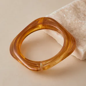 Close-up of square amber resin bracelet with tortoise texture on stone surface