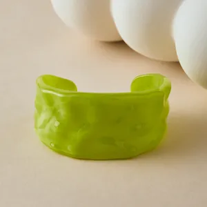 Vue détaillée du bracelet en acrylique vert avec texture ondulée irrégulière et design