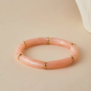 Detail of bohemian pink marble resin tube bracelet with golden spacer beads