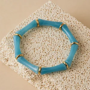 Pulsera de acrílico azul cielo estilo bambú con espaciadores dorados sobre piedra natural