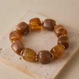 Detail eines Vintage-Armbands mit gemischten Harzperlen und goldenen Zwischenstücken