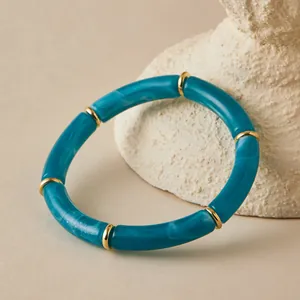 Detail of bohemian teal marble acrylic tube bracelet with gold metal spacer beads