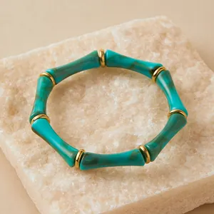 Detalle macro de la pulsera de acrílico efecto bambú mármol verde con aros dorados