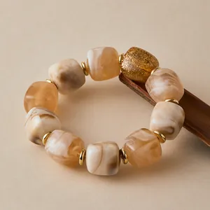 Detail von Marmorharz-Perlenarmband mit goldenen Abstandshaltern und Glitzerakzenten