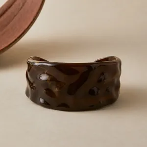 Détail macro du bracelet en résine ambrée avec texture plissée irrégulière unique