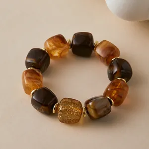Makroansicht der Vintage-Armband mit bernsteinfarbenen Harzperlen und Goldakzenten