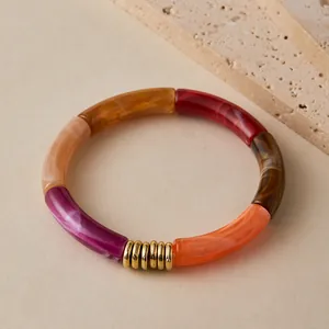 Detail of colorful resin bamboo-style tube bracelet with textured gold metal spacers