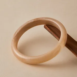 Bohemian amber acrylic bangle with marble texture on vintage wooden stand