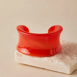 Detail of bohemian orange acrylic cuff bracelet with marble texture on stone base