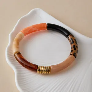 Detail of curved bamboo-style bracelet with multi-color acrylic beads and gold spacers