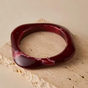 Close-up of thick square resin bangle with dark wine red and white marble texture