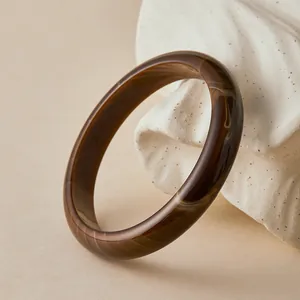 Detailed macro view of the polished amber resin bangle with smooth marble texture