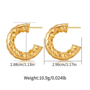 Detail view of gold C-shape earrings with irregular hammered texture and dimensions