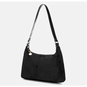 Detail of black faux fur underarm bag with gold zipper pendant and leather strap