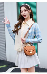 Brown quilted crossbody bag with semi-circle design and metallic buckle on model