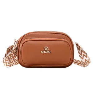 Brown litchi grain leather crossbody bag with dual zippers and woven shoulder strap