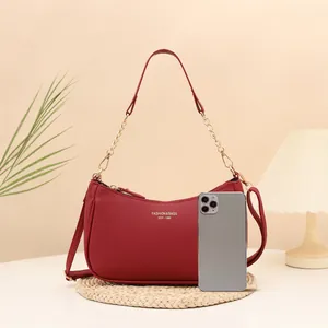 Red lychee texture leather shoulder bag with gold lettering and chain handle details