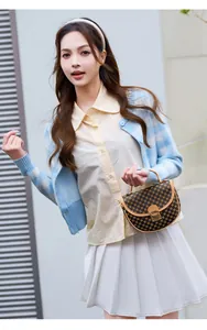 Close-up of a retro brown patterned semi-circle handbag paired with a plaid cardigan