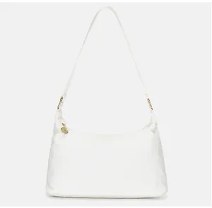 Detail of white canvas shoulder bag featuring golden metal rings and circular charm