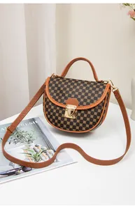 Macro view of vintage saddle bag with floral pattern and golden heart-shaped clasp