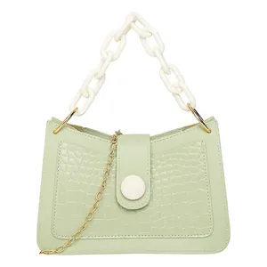 Mini borsa verde chiaro trama coccodrillo con manico in acrilico e bottone bianco