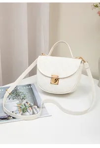 Close-up of white quilted semi-circle handbag with golden clasp and wave stitched strap