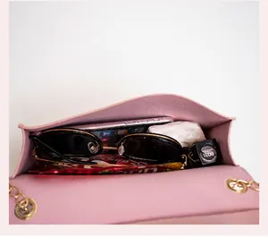 Interior view of pink crossbody bag showing capacity for phone, lipstick, and sunglasses