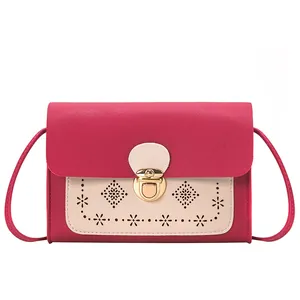 Petit sac bandoulière bicolore rose et crème avec motifs ajourés et fermoir doré