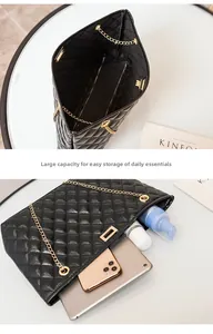 Detail of black quilted leather tote bag showing spacious interior for tablet and phone