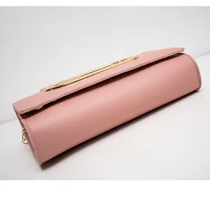 Close-up of pink lychee leather texture and gold metal chain hardware on crossbody bag