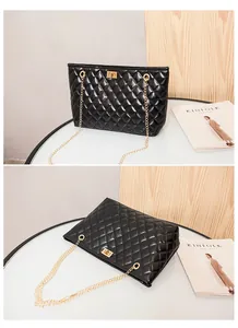 Detail of black quilted tote bag with golden chain straps and metallic twist lock