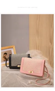Detail of grid texture cover and golden metal twist lock on the small square bag