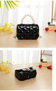 Detail of black jelly crossbody bag with pearl handle and quilted rhombus texture