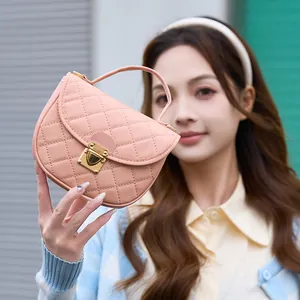 Pink quilted crossbody bag with golden metal buckle and top handle in a minimalist style