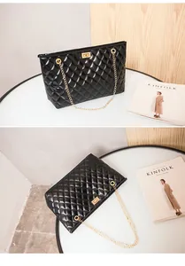 Close-up of black quilted shoulder bag with gold chain strap and square metal lock detail