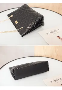 Detail of black quilted leather shoulder bag with gold metal chain and secure lock