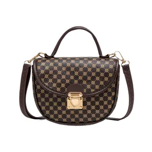 Brown monogram saddle bag with circular floral embroidery and golden heart lock