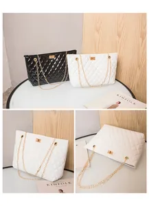 Close-up of black and white quilted tote bags with gold chain straps and turn-lock closures