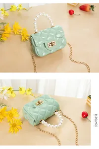 Macro shot of mint green jelly bag with diamond quilting and elegant pearl handle