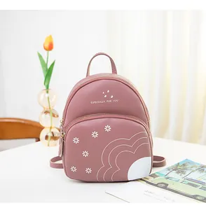 Detail of pink daisy print mini backpack showing textured leather and floral design