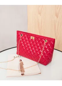 Detailed view of red quilted leather handbag with gold twist lock and chain strap