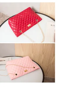 Detail view of red and pink quilted shoulder bags with gold chain straps and twist locks