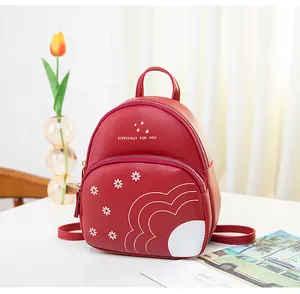 Detail of red floral mini backpack featuring daisy print and golden zipper accents