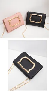 Detailed view of pink and black crossbody bags with gold cat-shaped metal clasps
