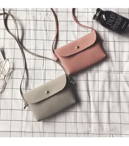 Detailed view of mini pink and grey crossbody bags with litchi grain texture