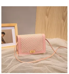 Detail of pink faux leather small square bag with beige mesh flap and gold twist lock