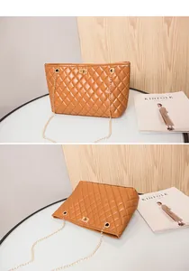 Close-up of brown quilted leather tote bag with gold metal twist lock and chain strap