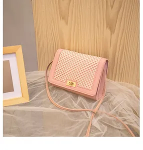 Detail of pink crossbody bag featuring cream woven mesh texture and gold twist lock clasp